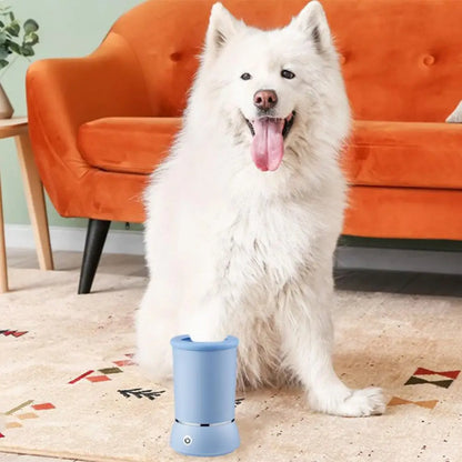 White fluffy dog sitting next to a blue automatic pet paw cleaner on a patterned rug in front of an orange sofa